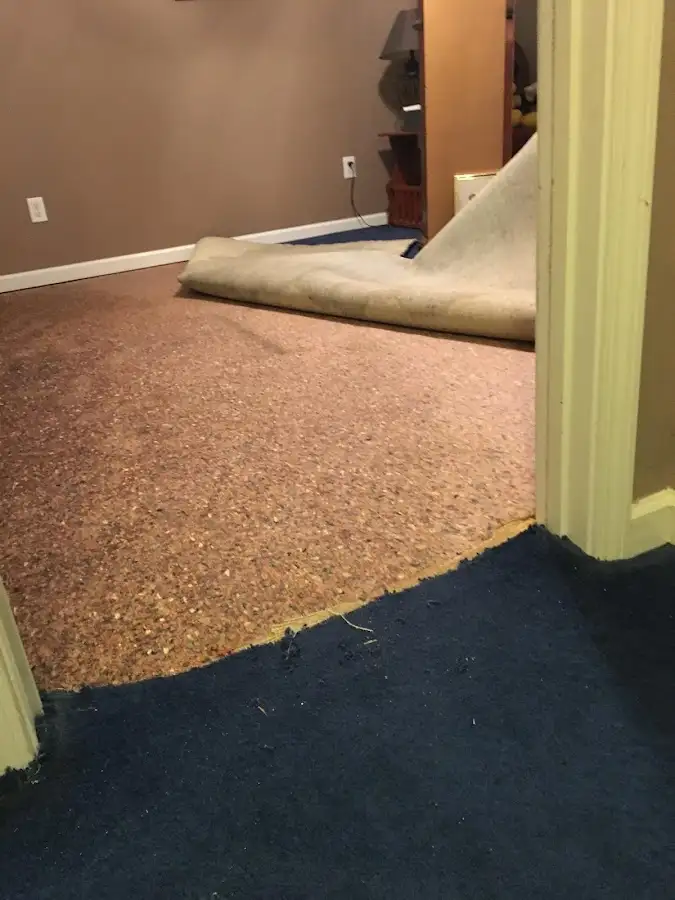 Carpet pad removal revealing water damage during Water Mitigation Services in Yorkshire